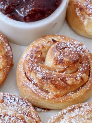 monte cristo rolls on a plate topped with powdered sugar