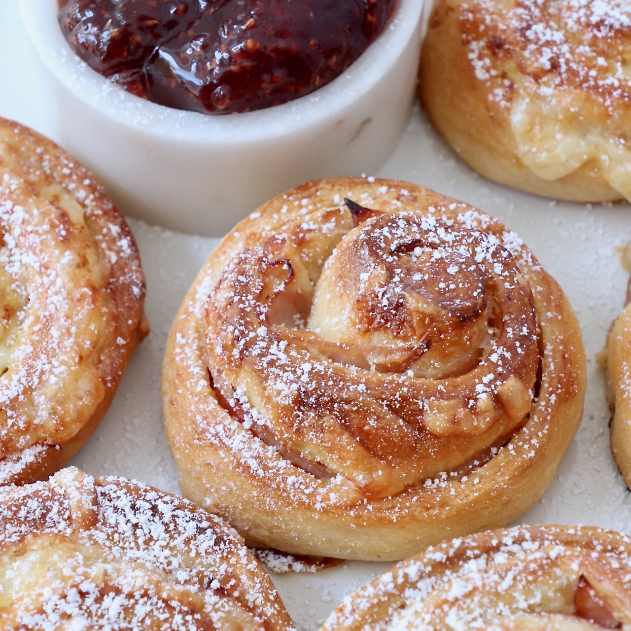 monte cristo rolls on a plate topped with powdered sugar