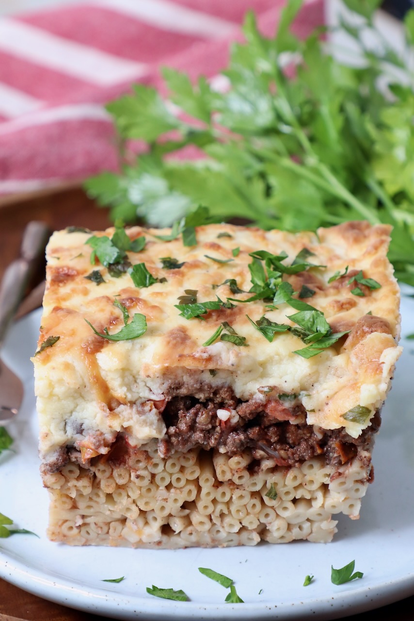 slice of pastitsio on plate with fresh parsley