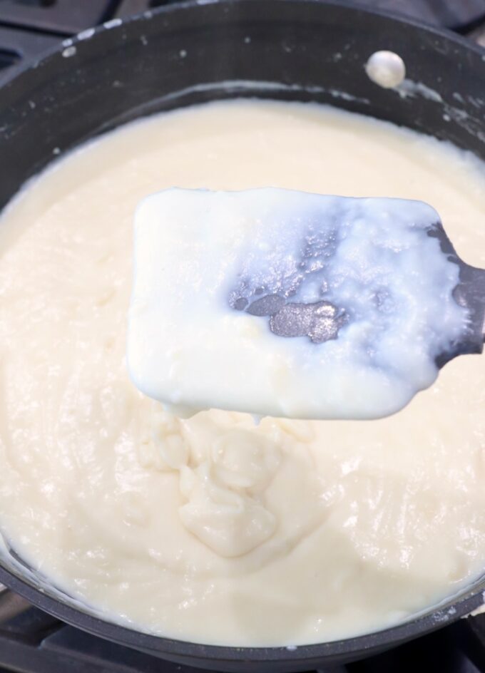 creamy bechamel sauce in skillet with spatula