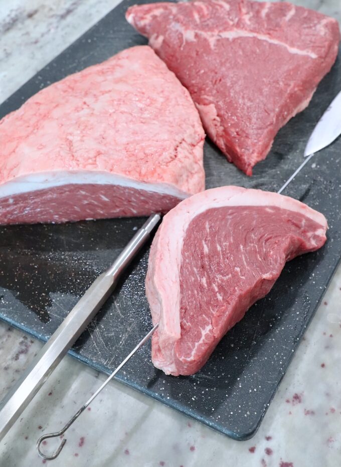 piece of steak with a metal skewer through the steak