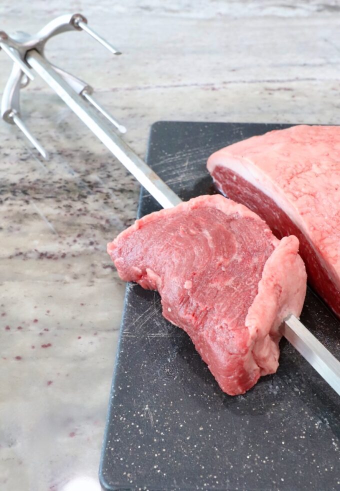 piece of steak on a rotisserie rod