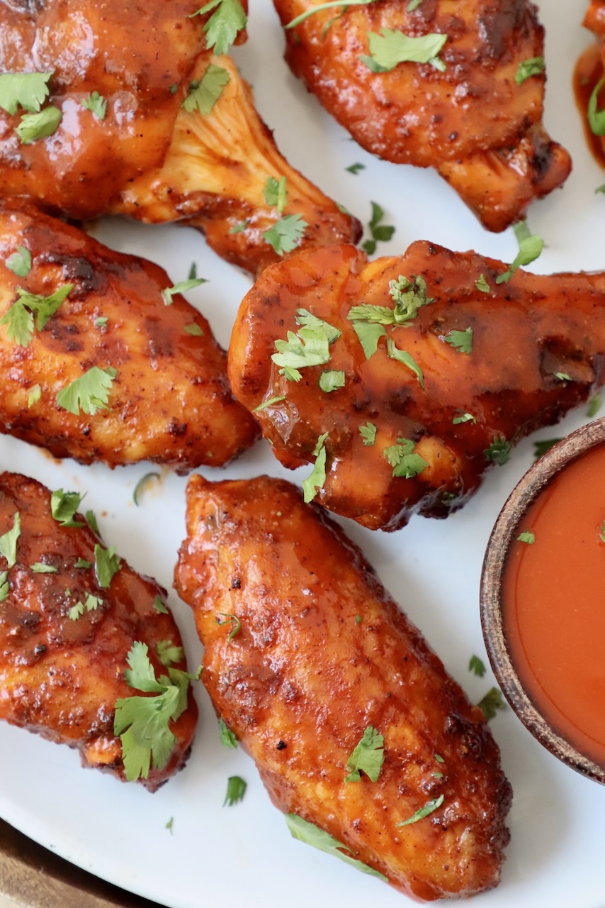 smoked chicken wings tossed with buffalo sauce on plate