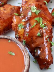 smoked chicken wings on plate tossed with buffalo sauce