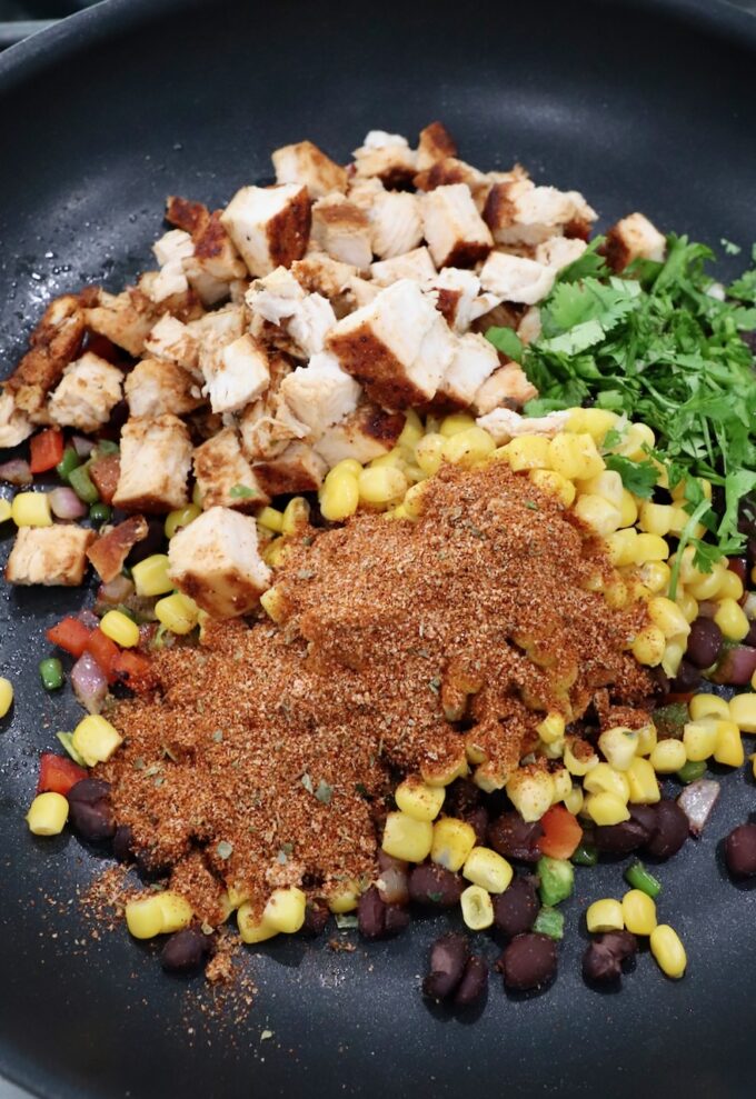 vegetables, diced chicken and taco seasoning in skillet
