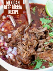 shredded beef in birria broth in a bowl with forks