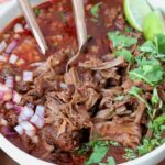 shredded beef birria in bowl with broth