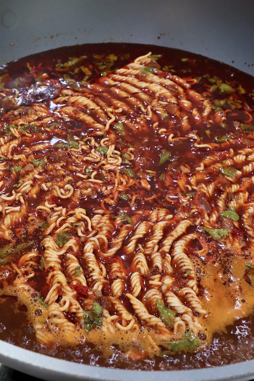 Instant ramen noodles in large pot of birria broth
