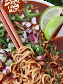 cooked ramen noodles lifted up with chopsticks in bowl of birria broth