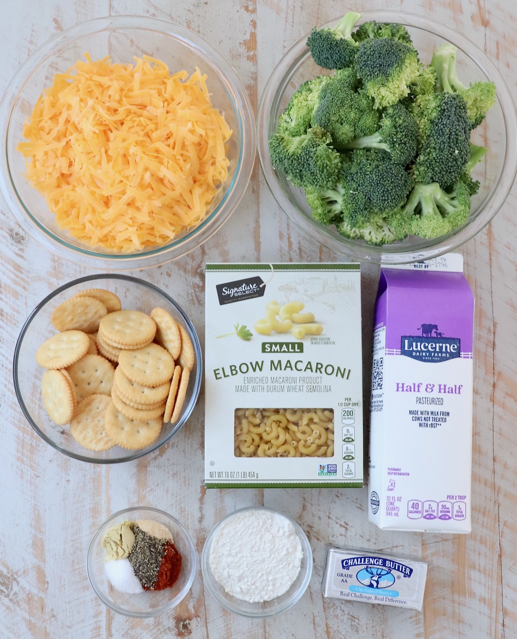 ingredients for broccoli mac and cheese on white wood board