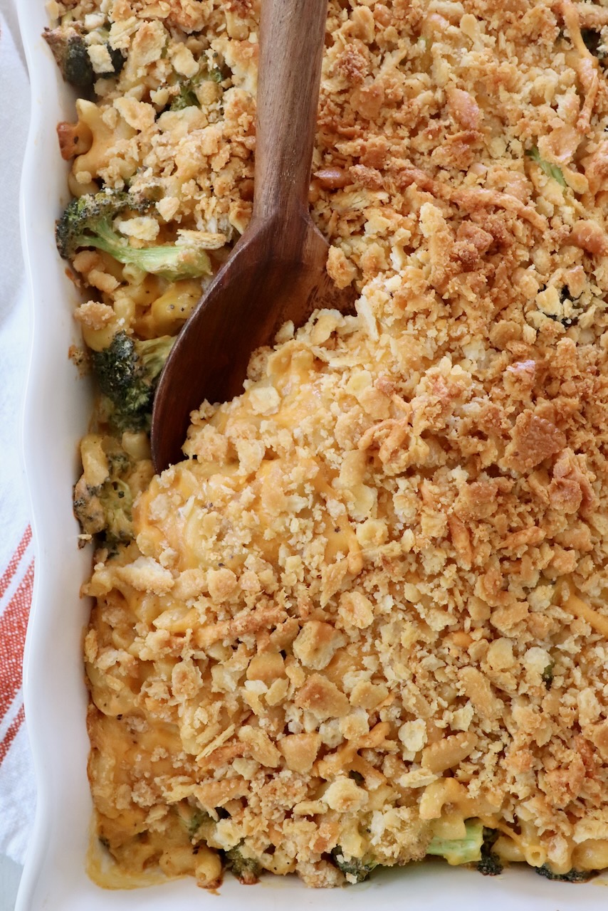 baked broccoli macaroni and cheese in baking dish with serving spoon
