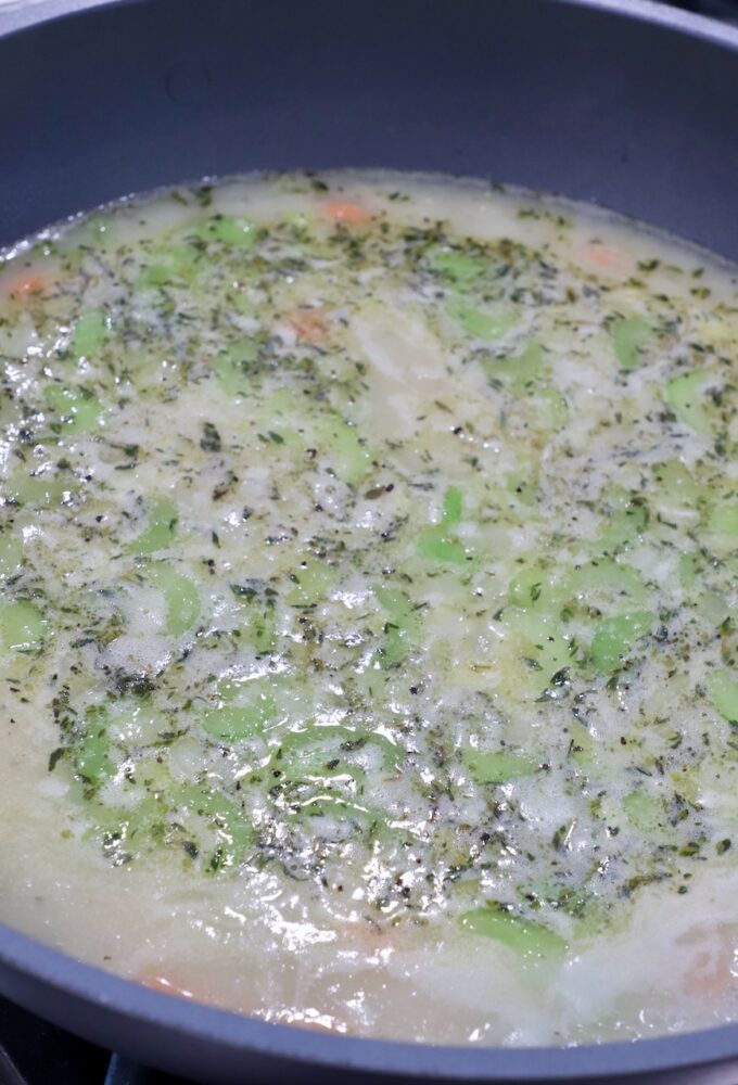 seasoned chicken broth and diced vegetables in skillet