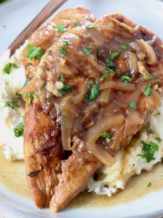 cooked french onion chicken breasts on plate with mashed potatoes