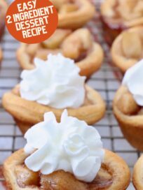 mini apple pies on wire rack topped with whipped cream