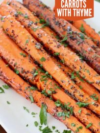 whole roasted carrots on white plate with fresh chopped parsley