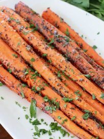 roasted carrots on plate topped with fresh chopped parsley