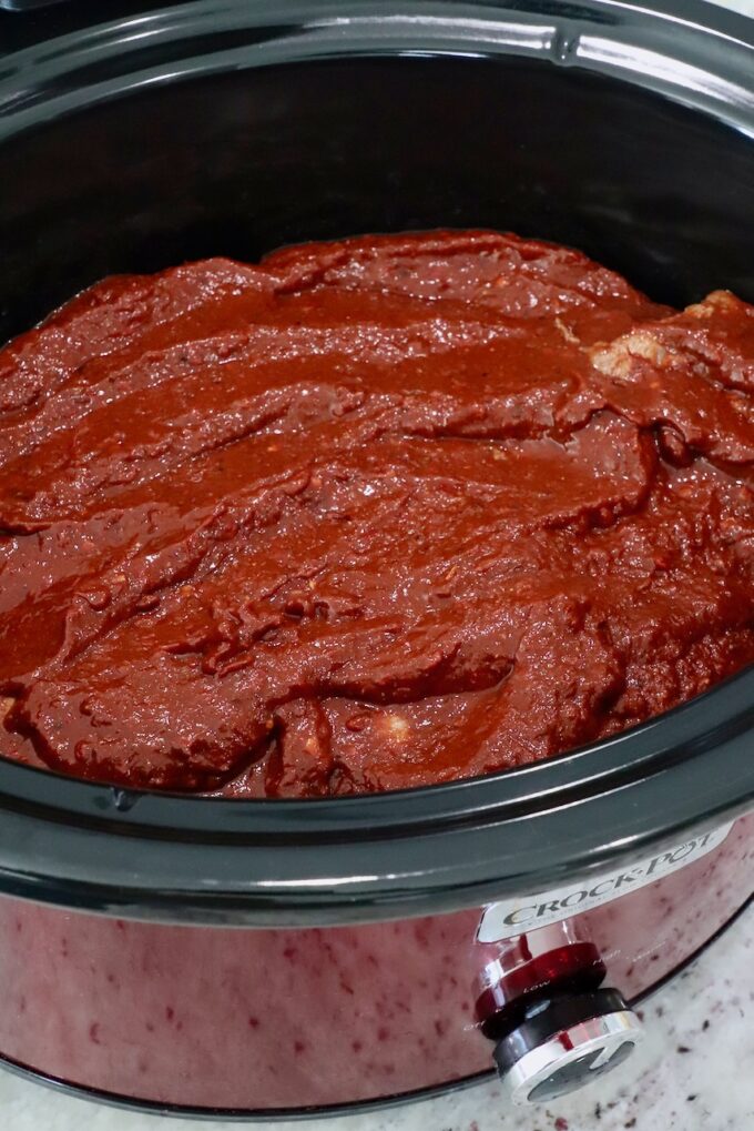 beef covered in tomato chili sauce in a crock pot