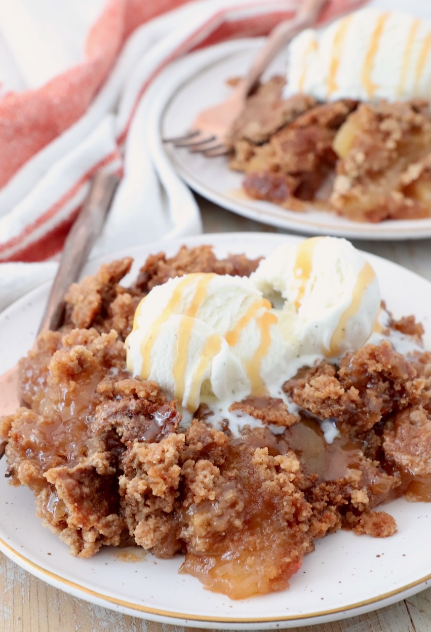 apple dump cake served on plates, topped with a scoop of ice cream