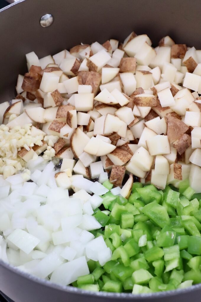 diced potatoes, green peppers and onions in large dutch oven