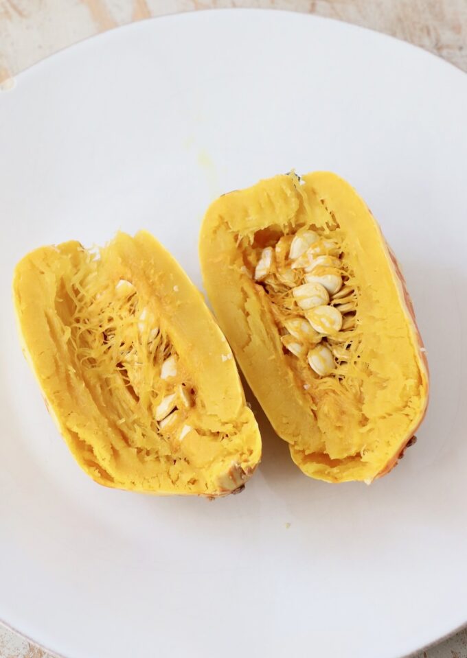 cooked delicata squash cut open on plate