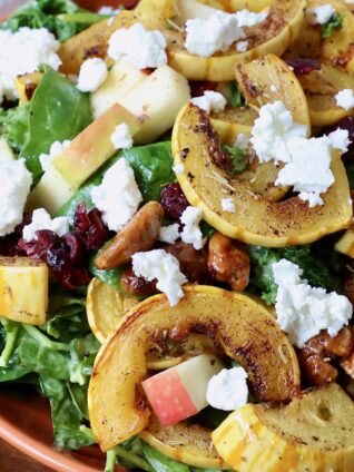 salad topped with roasted delicata squash and crumbled goat cheese