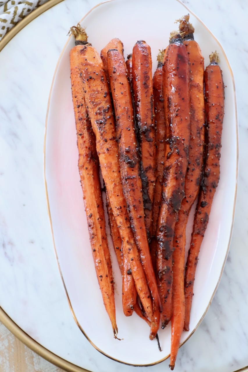 glazed roasted carrots stacked up on plate