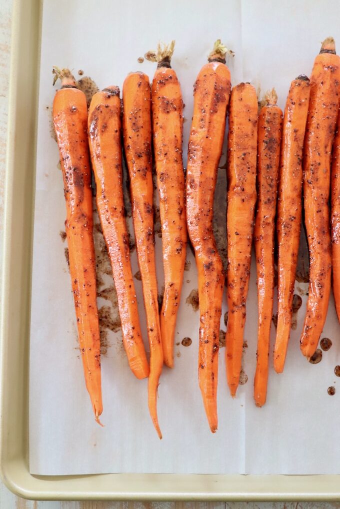 honey glazed carrots on parchment lined baking sheet