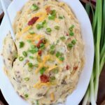 loaded mashed potatoes in serving dish with spoon