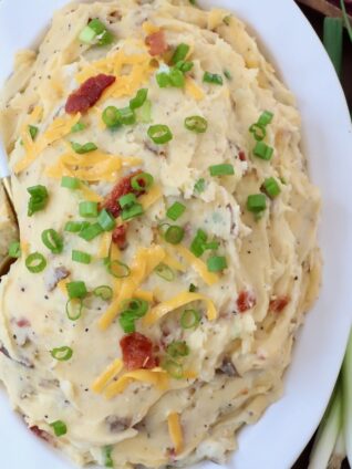 loaded mashed potatoes in serving dish with spoon