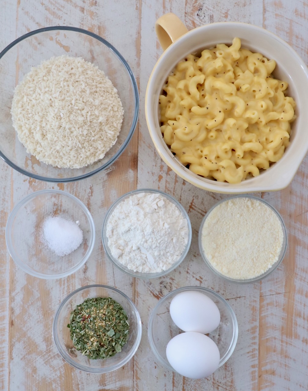 mac and cheese bites ingredients on white wood board