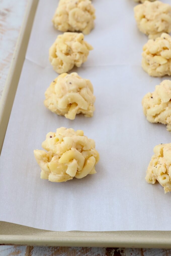 balls of mac and cheese on parchment lined baking sheet