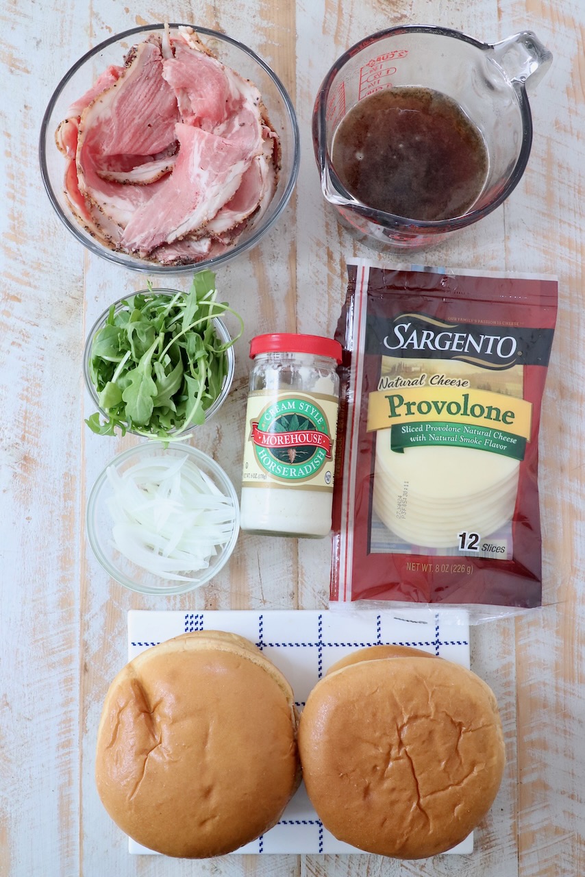 ingredients for roast beef sandwiches on white wood board