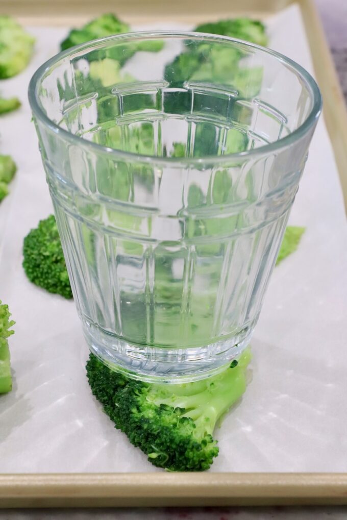 glass cup on top of a piece of broccoli on a baking sheet