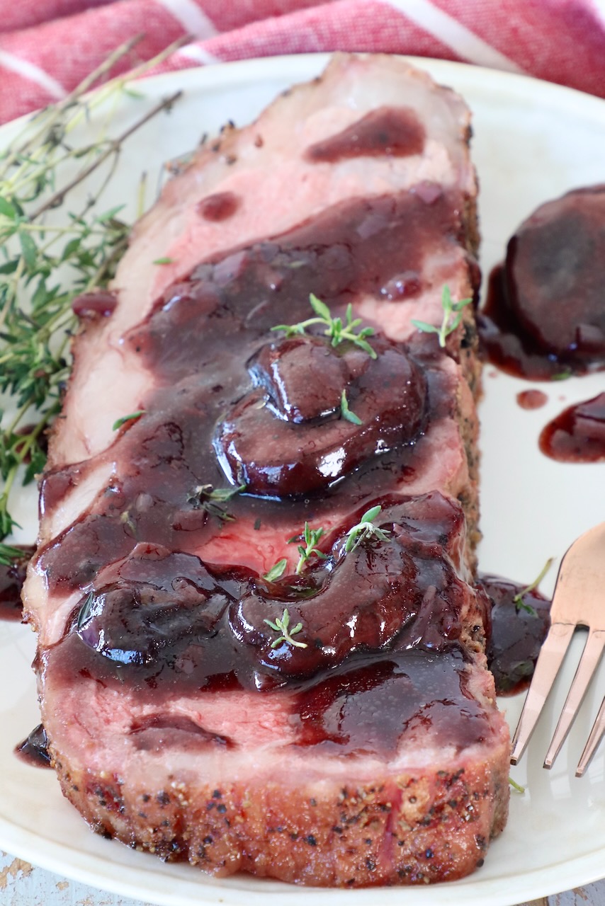 smoked new york strip steak on plate, covered in red wine sauce