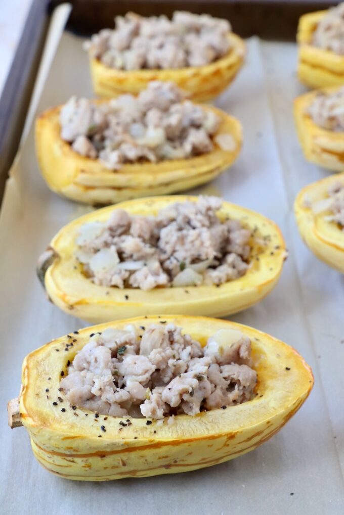 roasted delicata squash cut in half and filled with cooked ground sausage