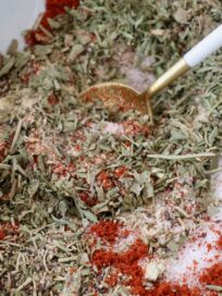 herbs and spices mixed together in bowl with a spoon