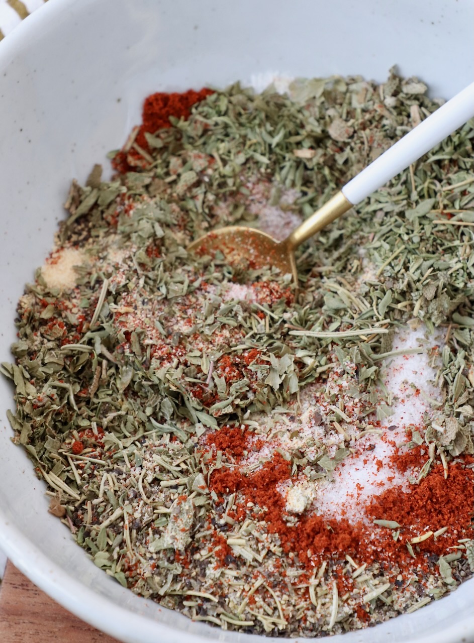 herbs and spices mixed together in bowl with a spoon