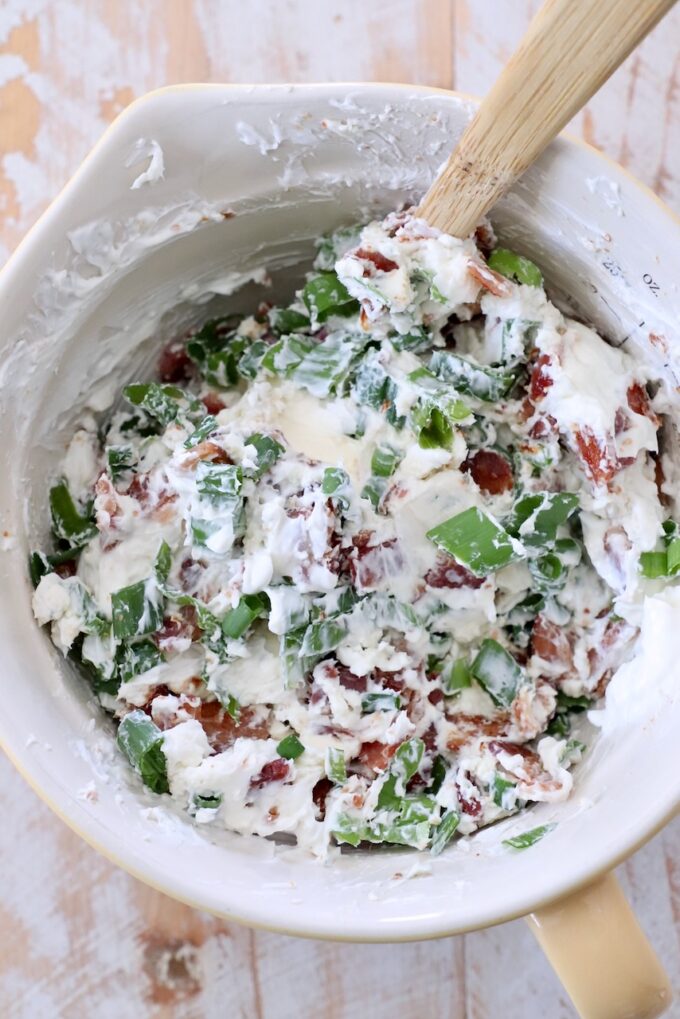 cream cheese, combined with blue cheese, chopped bacon and diced green onions in a bowl