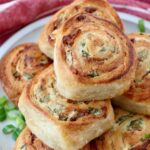 baked cheesy bacon crescent rolls stacked up on a plate