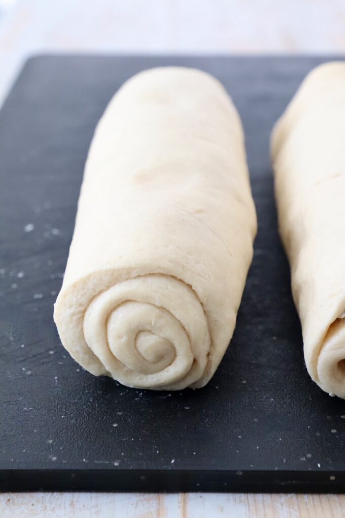 crescent roll dough rolled up on cutting board