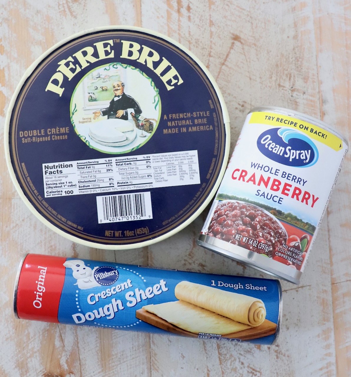 ingredients for baked brie bites on white wood board