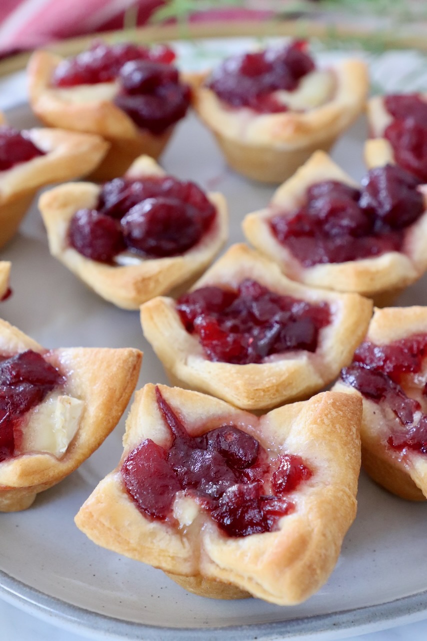 baked brie bites topped with cranberry sauce on a plate
