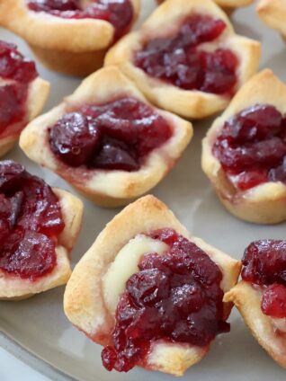 baked brie bites topped with cranberry sauce on plate