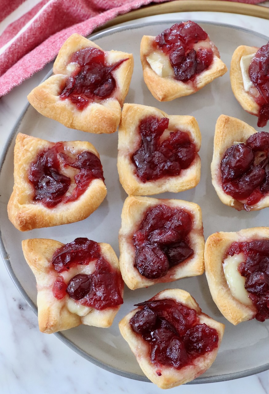 baked brie bites, topped with cranberry sauce on plate