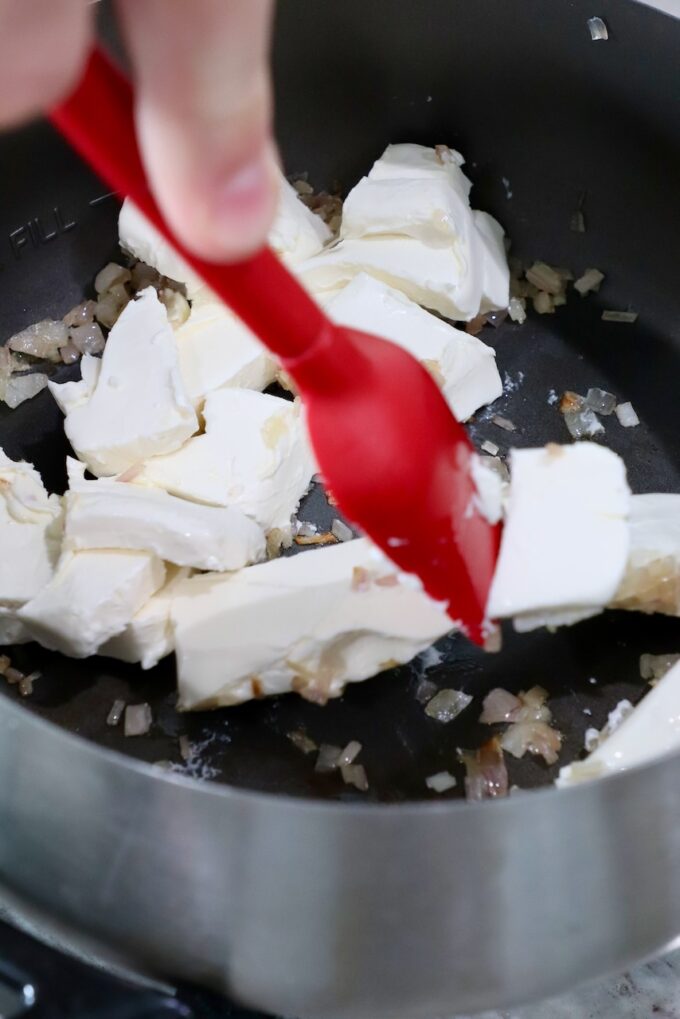 cream cheese in fondue pot with red spatula