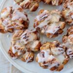 pull apart cinnamon rolls on plate topped with cream cheese icing