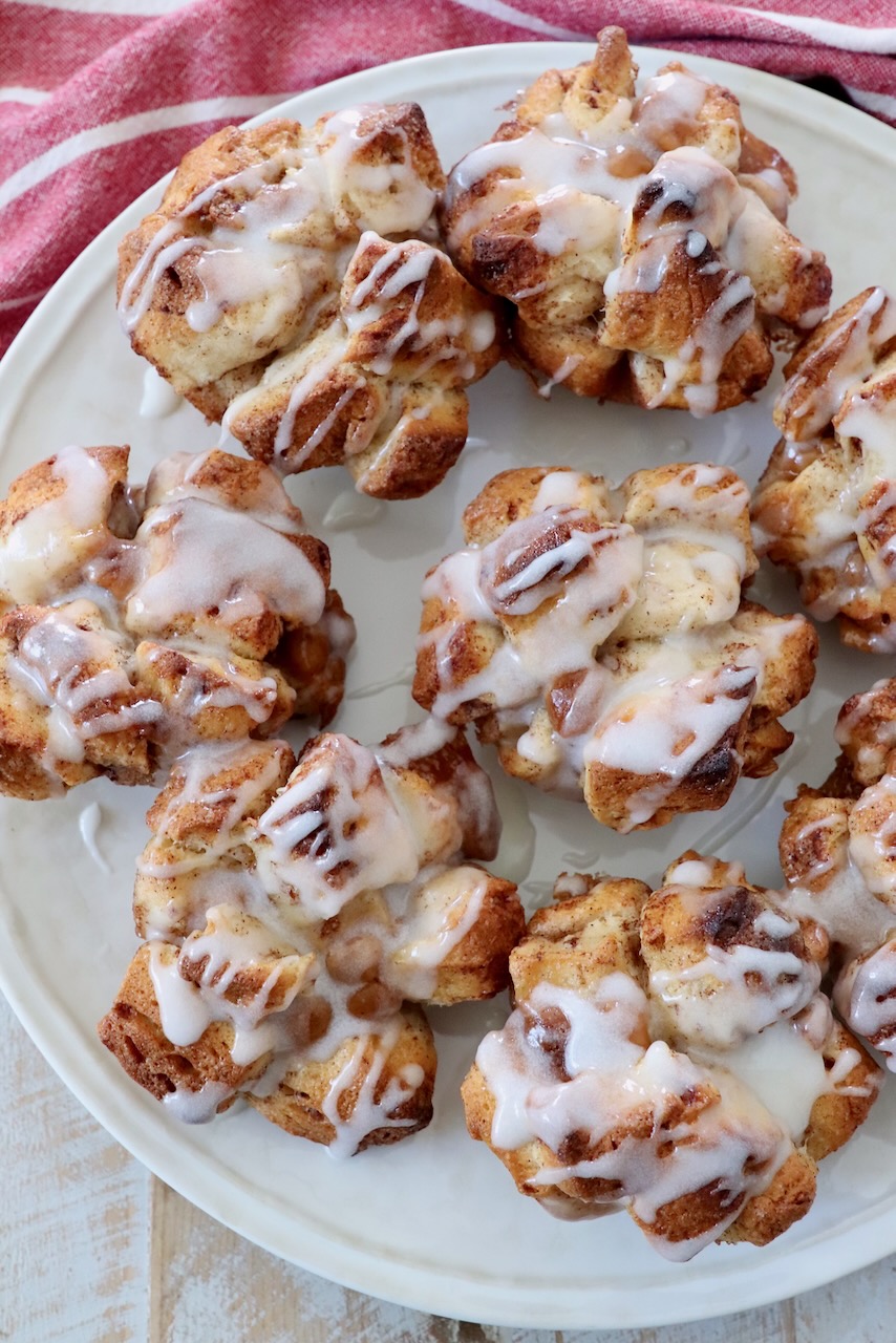 pull apart cinnamon rolls on plate drizzled with cream cheese icing