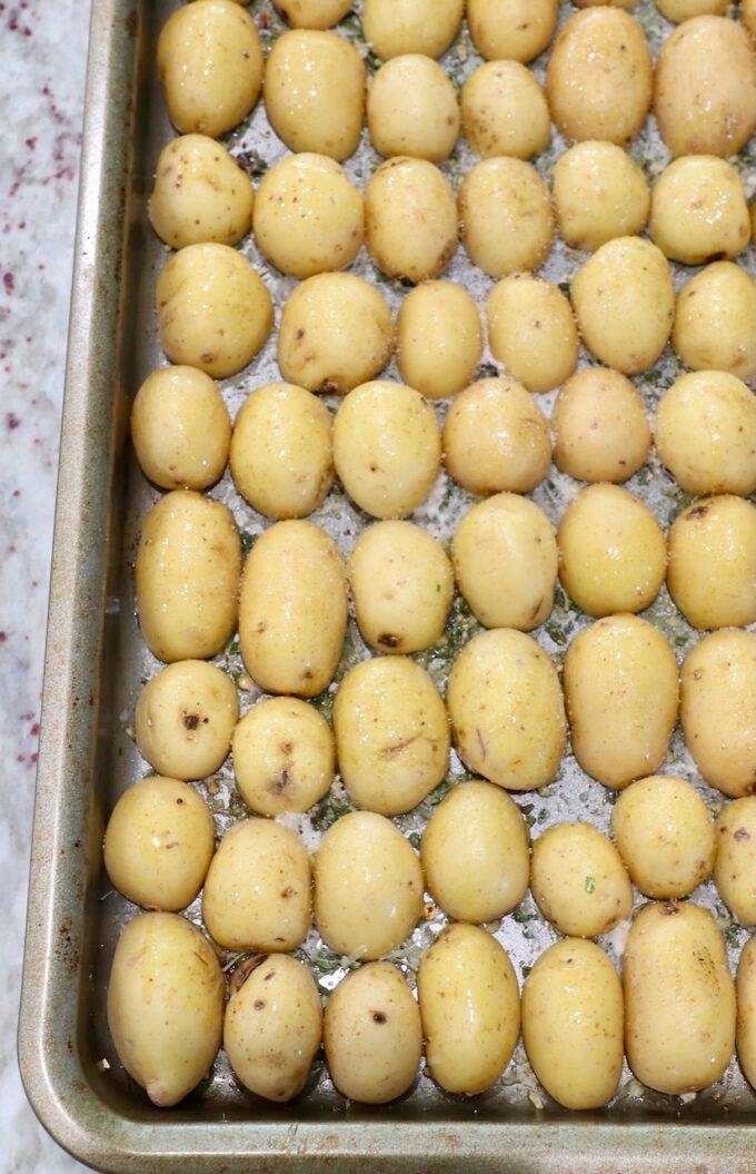 baby potatoes sliced in half on baking sheet