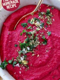 beet hummus in bowl with gold spoon