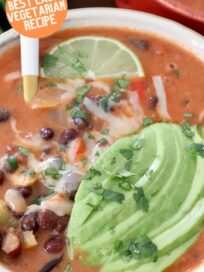 black bean soup in bowl topped with sliced avocado